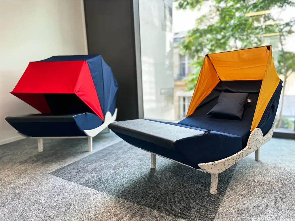 Deux cocons de micro-sieste dans une salle lumineuse avec une baie vitrée