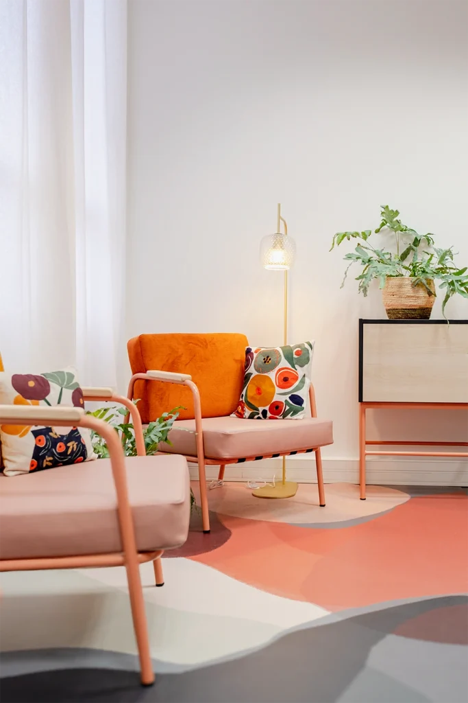 Salle de repos colorée avec deux fauteuils modernes, une lampe et une plante dans une pièce bien éclairé