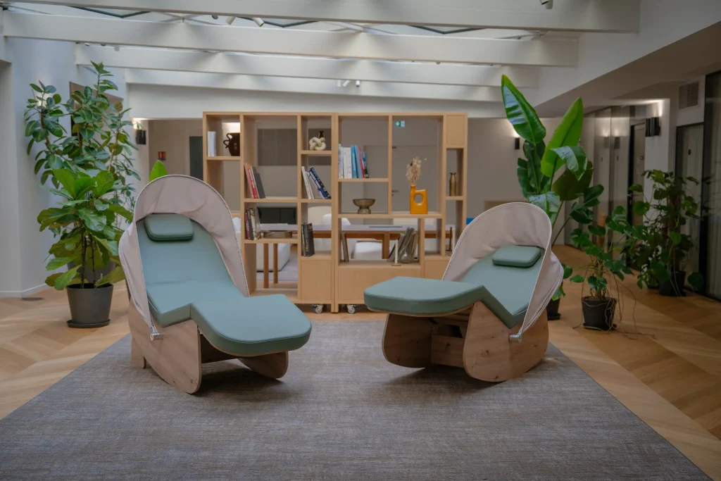 Deux cocons de sieste vert sauge dans une salle de pause reposante