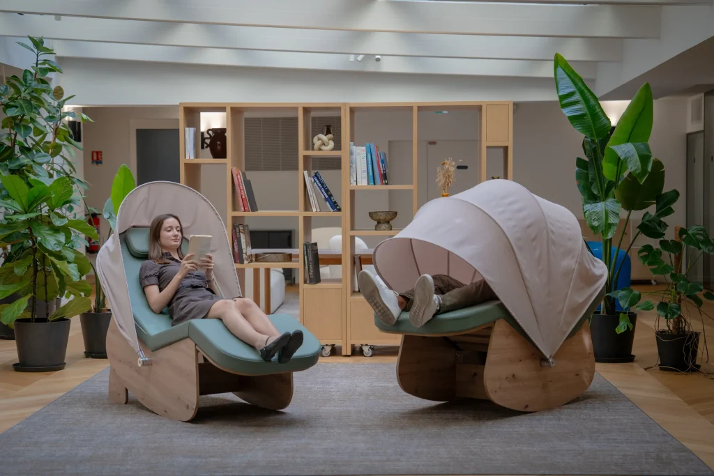 Deux cocons de sieste vert sauge dans une salle de pause reposante