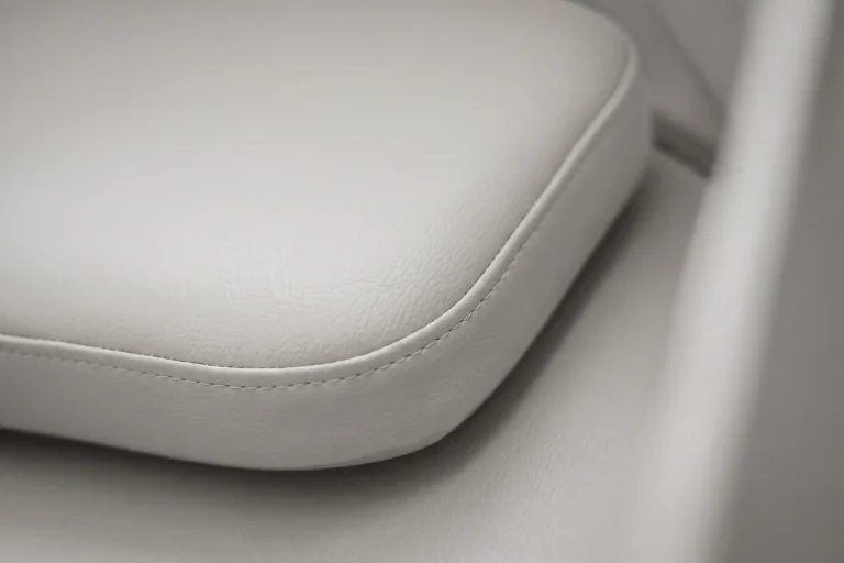 Détail du matelas coloris perle sur un fauteuil de micro-sieste, finition texturée confortable