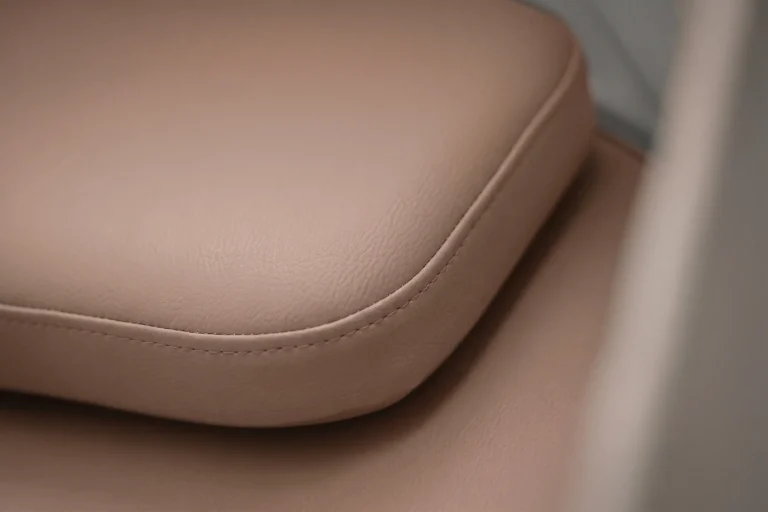 Détail du matelas coloris rose poudré sur un fauteuil de micro-sieste, finition texturée confortable
