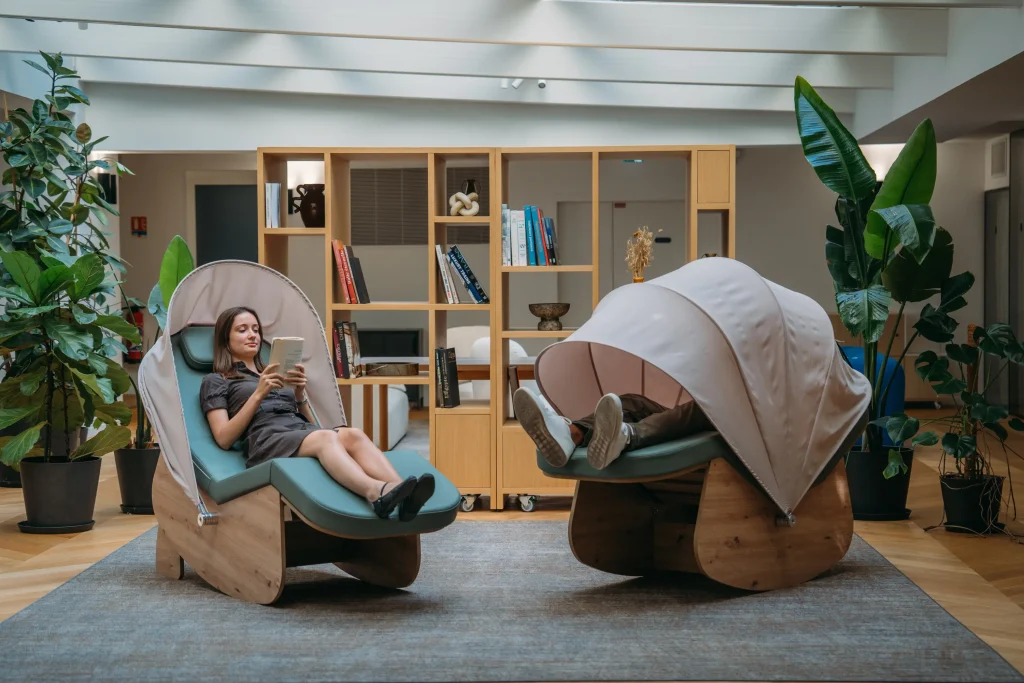Deux cocons de sieste vert sauge dans une salle de pause reposante